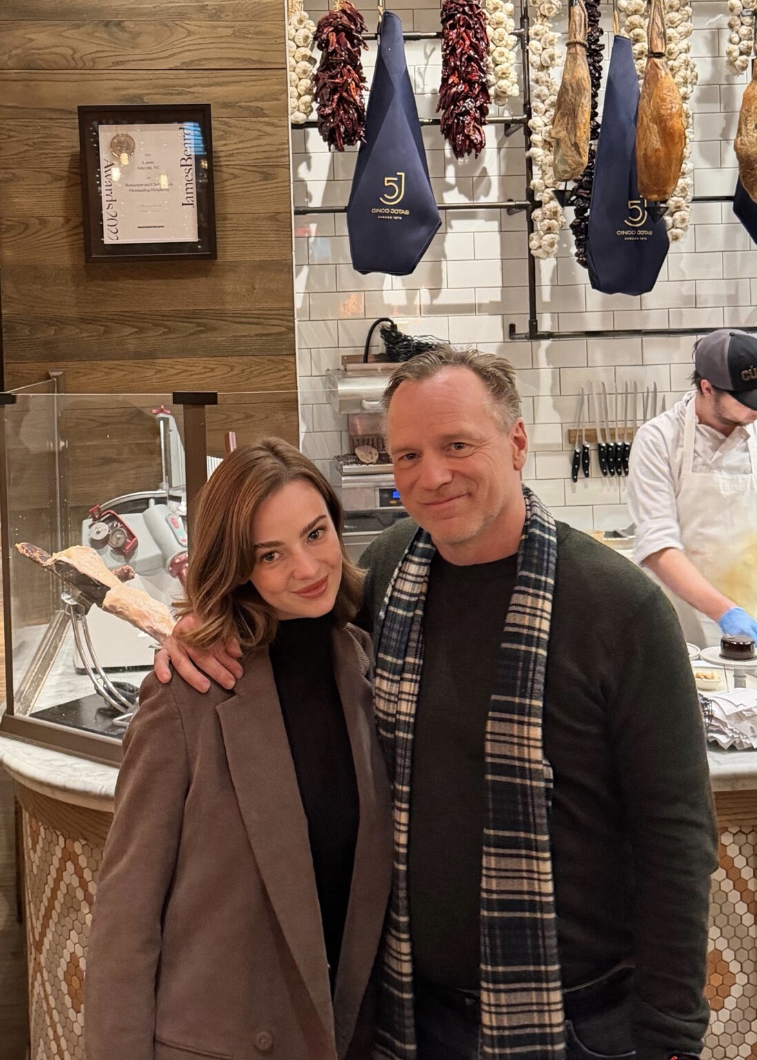 Madison Campbell wearing a brown coat at a restaurant